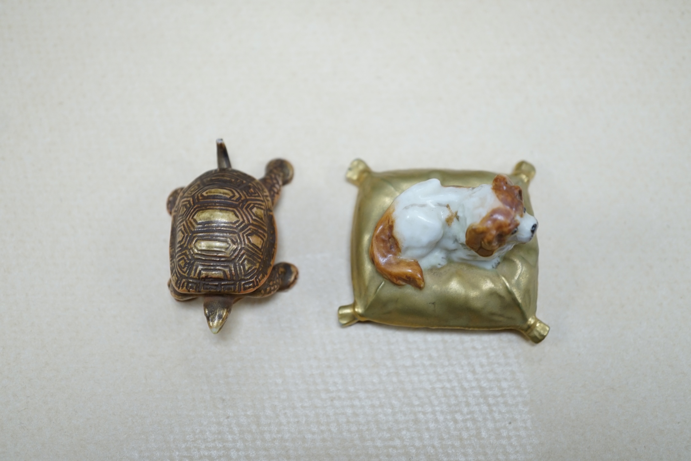 An unusual Royal Worcester miniature King Charles Spaniel sitting on cushion and tortoise, 4cm wide. Condition - fair